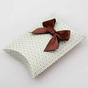 Pillow-shaped gift box with green geometric pattern and brown satin ribbon bow decoration