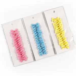 Close-up of colorful mini gift bows on white card for bakery and craft packaging