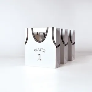Drie creatieve witte papieren cadeautassen in basketbalshirt ontwerp met zwarte print
