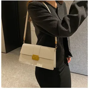 Detail of cream shoulder bag featuring sleek synthetic leather and gold metallic lock