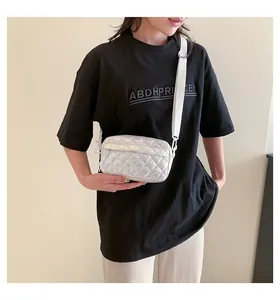 Details der silbernen gesteppten Umhängetasche mit verstellbarem weißem Gurt am Model