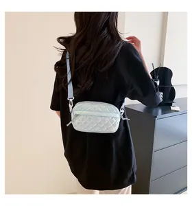 Rückansicht eines Models mit hellblauer holografischer Stepptasche und Harzschnalle