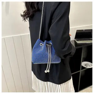 Detail van koningsblauwe emmertas met strass-steentjes, zilveren ketting en koord