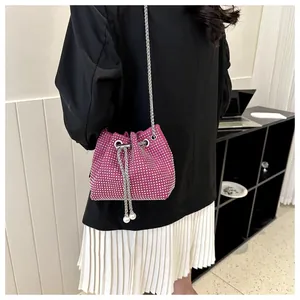 Detailopname van de rozerode strass emmer-tas met kettingriem en parel trekkoord