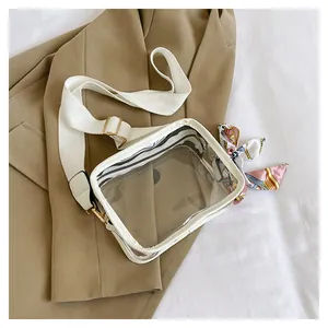 Transparent PVC crossbody bag with white fabric strap and pink decorative scarf detail