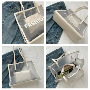 Detail view of transparent PVC tote bag with white leather straps and interior pouch
