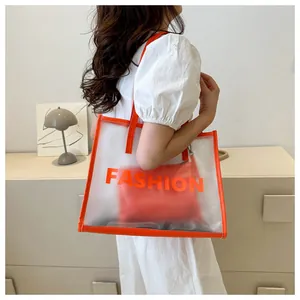 Detail of clear PVC tote bag with orange leather trim and interior fashion pouch