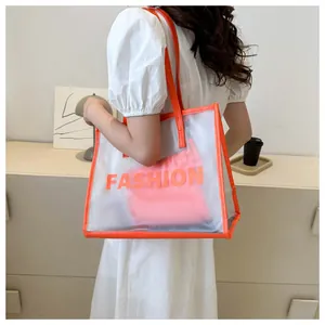 Detail of transparent PVC tote bag with orange leather trim and Fashion print