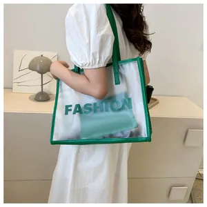 Detail of transparent PVC tote bag with green leather trim and interior zip pouch