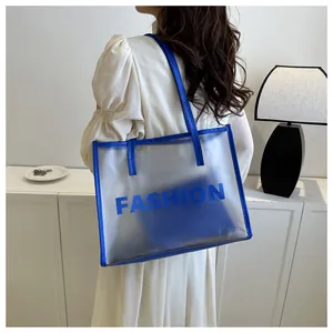 Detail view of transparent PVC tote bag with blue trim and fashion print lettering