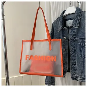 Close-up of frosted semi-transparent tote bag with orange edges and FASHION lettering