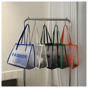 Row of colorful semi-transparent PVC tote bags with Fashion print hanging in a neat studio
