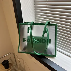Minimalist transparent PVC tote bag with green leather trim and FASHION lettering