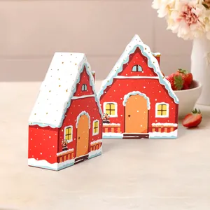 Festive red house-shaped gift boxes with snow-capped roofs for cookies and sweets