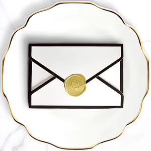 Elegant envelope wedding candy box with gold wax seal on a marble textured background