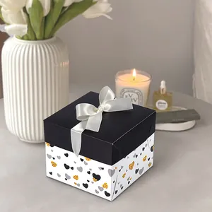 Elegant square gift box with black lid, white ribbon bow, and stylish heart patterns