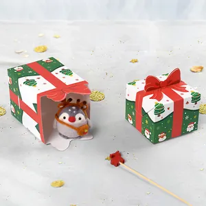 Weihnachtsgeschenkboxen mit roten Schleifen und Weihnachtsmann-Motiven im Schnee
