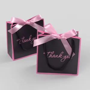 Detail of small black gift bags with pink ribbon bows and Thank You print text