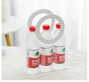 Transparente PVC-Geschenktüte mit weißen runden Griffen und drei Wasserflaschen darin