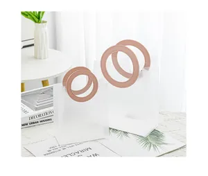 Detailansicht der mattierten Geschenktüten mit runden rosa Ledergriffen auf Spitze