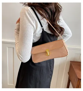 Chic vintage underarm bag featuring a gold U-shaped lock and glossy leather texture