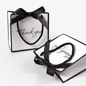 Minimalist white gift paper bag with black trim, Thank You print, and elegant bow decoration