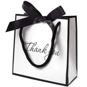 Minimalist white gift bag with black trim, satin bow, and Thank You lettering