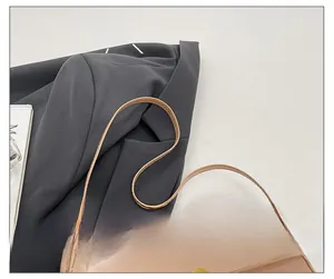 Detail view of the sleek glossy faux leather surface and golden clasp of this chic handbag