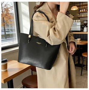Detailaufnahme einer schwarzen Leder-Tragetasche mit goldener Aufschrift im Streetstyle