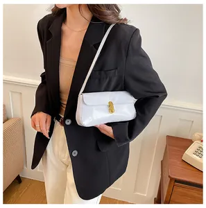 Close-up of white patent leather shoulder bag with sleek gold metal clasp and thin strap