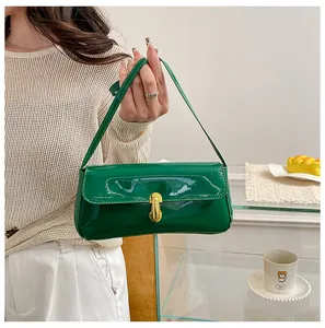 Detail of green patent leather shoulder bag featuring a gold rotating lock closure
