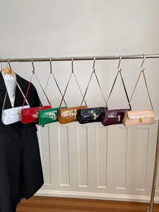 Glossy patent leather baguette bags in various colors with golden U-shaped buckles