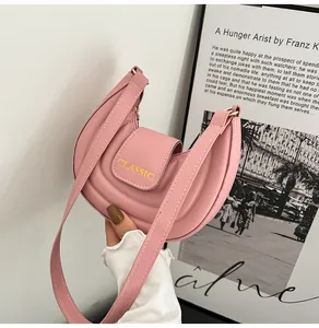 Dettaglio della borsa a sella rosa con trama ondulata e logo dorato classico