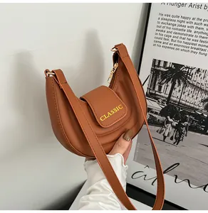 Dettaglio della borsa a sella marrone vintage con stampa CLASSIC dorata e pelle opaca