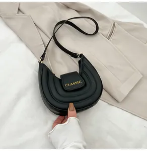 Dettaglio borsa a sella nera a pieghe con testo Classic dorato e similpelle PU premium