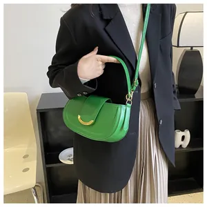 Detail of lime green saddle bag with gold crescent buckle on a stylish model
