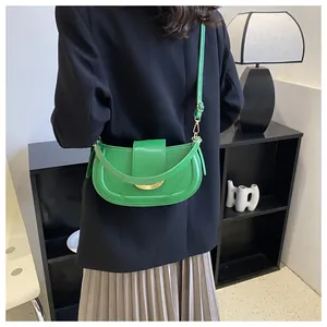 Close-up of bright green semi-circle shoulder bag with gold crescent buckle detail