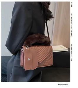 Detail view of tan quilted handbag with faux fur handle and detachable small pouch
