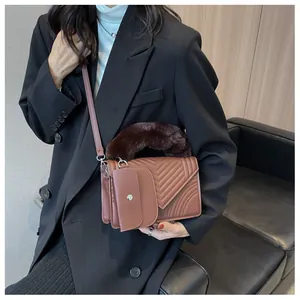 Detail of terracotta V-quilted handbag with plush faux fur handle and a matching coin purse