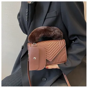 Detail of brown quilted faux leather handbag with plush fur handle and mini pouch