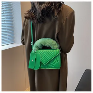 Detail view of quilted bright green leather bag with plush handle and mini coin purse