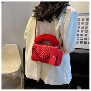 Detail of red quilted faux leather bag with fluffy plush handle and matching mini pouch