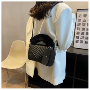 Chic black quilted crossbody bag featuring a plush faux fur handle and small coin purse