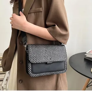 Λεπτομέρεια υφασμένης τσάντας tweed με μαύρο τεχνητό δέρμα και φαρδύ ιμάντα ώμου καμβά