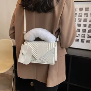 White V-quilted shoulder bag with faux fur handle and mini pouch on brown blazer
