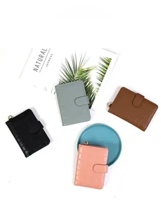 Detail of four crocodile textured passport holders in black, green, brown, and pink finishes