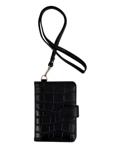 Detail view of black crocodile pattern passport holder with neck strap and gold buckle