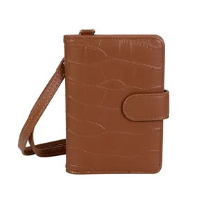 Close-up of brown crocodile pattern embossed PU leather on a small crossbody phone bag