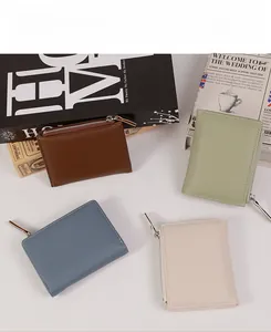 Detail of four colorful litchi-textured leather wallets with silver metal zippers