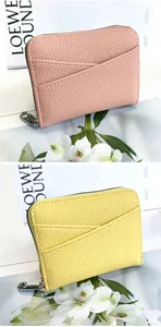 Detail of pink and yellow leather card holders with zip closure and layered slots